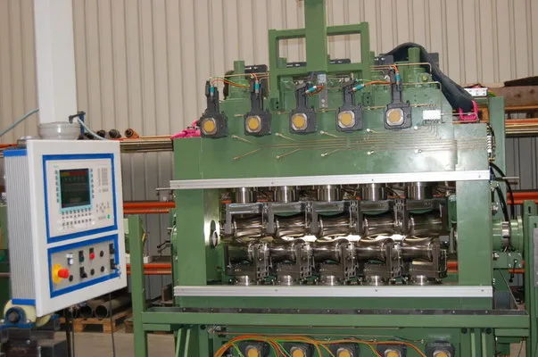 Rohrrichtmaschine mit mehreren Richtrollen und Steuerpult in einer Werkhalle
